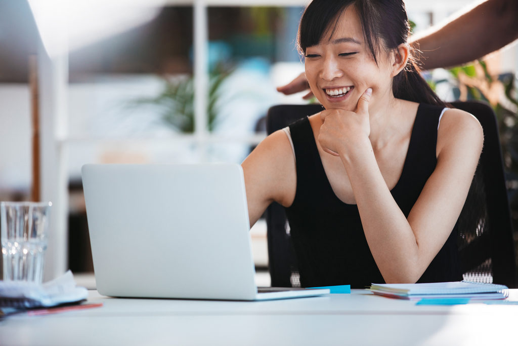 Smiling woman working on laptop at office