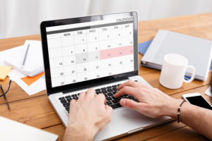 Man Working With Calender Planner On Laptop In Office, Managing Business Schedule