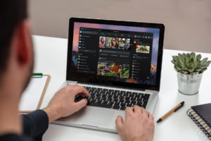 Laptop with white blank screen on a wooden desk